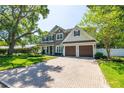 Charming two-story home boasting a well-manicured lawn, mature trees, and a brick-paved driveway at 4010 W Leona St, Tampa, FL 33629