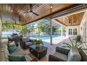Relaxing screened-in patio featuring comfortable seating, ceiling fans, and a view of the pool area at 4010 W Leona St, Tampa, FL 33629
