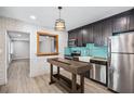 Modern kitchen featuring stainless steel appliances, dark cabinets, and a stylish light fixture at 4527 24Th S Ave, St Petersburg, FL 33711