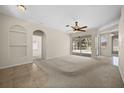 Neutral living room features tile floors, a ceiling fan, sliding glass doors, and backyard views at 4538 Appleton Ter, North Port, FL 34286