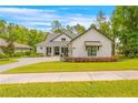 Charming home with a manicured lawn, dark trim, decorative awning, and attractive landscaping at 4581 Majestic Hills Loop, Brooksville, FL 34601