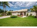 A well kept front yard of a single-story home with lush grass and flower beds at 5519 Greyston St, Palm Harbor, FL 34685