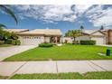 Well-maintained single-story home with a garage and lush front yard at 5519 Greyston St, Palm Harbor, FL 34685