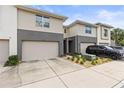 Neutral-toned townhome with garage, complemented by landscaped front and a blue sky above at 6406 Sanctuary Creek Ln, Tampa, FL 33625