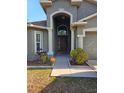 Inviting front entrance with a decorative archway, manicured landscaping, and a well-maintained walkway at 6933 Waterbrook Ct, Gibsonton, FL 33534