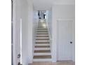 Bright stairway with neutral-toned stairs, white walls, and a closed door, providing access to upper levels at 7647 Navigator Ct, Port Richey, FL 34668