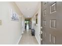 Inviting condo hallway with tiled floors, neutral paint, and bench seating for convenience at 9450 Harbor Greens Way # 403, Seminole, FL 33776