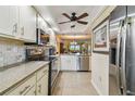 Bright kitchen with stainless appliances, tiled backsplash, and view into dining area at 9450 Harbor Greens Way # 403, Seminole, FL 33776
