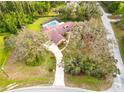 A sprawling single-Gathering home features mature landscaping, a long driveway, and an in-ground pool with screened enclosure at 10206 Lakeview Dr, New Port Richey, FL 34654