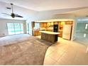 The kitchen overlooks the living room and features wood cabinets, tile floors, and a center island with a wine rack at 10206 Lakeview Dr, New Port Richey, FL 34654