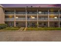Exterior view of a three-story condo building with white railings and well-maintained landscaping at 10215 Regal Dr # 21, Largo, FL 33774
