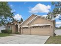 Exterior view of the home showing the three-car garage and well-kept lawn at 10322 Riverburn Dr, Tampa, FL 33647
