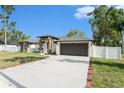 Charming single-story home with a well-manicured lawn and inviting entrance with a gray two-car garage at 106 Ne 1St Ave, Lutz, FL 33549