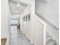 Inviting hallway with neutral walls, tile flooring, and staircase, seamlessly connecting the home's different spaces at 11717 Blackbrook Ct, Seffner, FL 33584