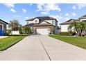 Two-story home with a two-car garage, solar panels, and a well-maintained lawn in a suburban neighborhood at 11841 Thicket Wood Dr, Riverview, FL 33579