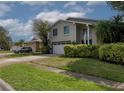 Charming two-story home with a two-car garage and well-manicured front yard at 1326 Moss Dr, Dunedin, FL 34698