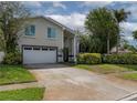 Charming two-story home featuring a two-car garage, well-maintained lawn, and lush landscaping at 1326 Moss Dr, Dunedin, FL 34698