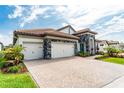 Beautiful single-story home featuring a tile roof, a paver driveway, manicured lawn and beautiful landscaping at 148 Mossy River Ct, Brandon, FL 33511