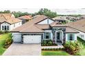 Beautiful exterior view of home with tile roof, brick driveway, and neatly landscaped yard with healthy green grass at 148 Mossy River Ct, Brandon, FL 33511