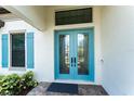 Elegant double front door with transom window and blue trim accents create a welcoming entrance at 148 Mossy River Ct, Brandon, FL 33511