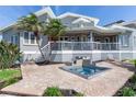 Backyard featuring a relaxing spa with a decorative water feature with palm trees and waterfront views at 17382 Kennedy Dr, North Redington Beach, FL 33708