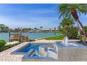 Backyard including a rejuvenating water feature overlooking the canal lined with palm trees at 17382 Kennedy Dr, North Redington Beach, FL 33708