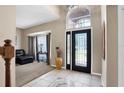 Inviting home foyer featuring tile flooring, a large front door with glass, and a soaring window above at 1751 Split Fork Dr, Oldsmar, FL 34677