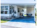 Cozy single-story home with a covered carport, quaint front entry, and cheerful decor elements at 18675 Us Highway 19 N # 140, Clearwater, FL 33764