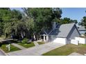 Aerial view of home with a well-manicured lawn, mature trees, and a two-car garage at 1916 River Crossing Dr, Valrico, FL 33596
