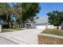 Charming single-story home with a two-car garage and a beautifully landscaped front yard with mature trees at 1916 River Crossing Dr, Valrico, FL 33596
