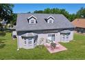 The rear exterior features a patio, sliding glass door, and two bay windows, all overlooking the well maintained lawn at 24314 Landing Dr, Lutz, FL 33559