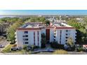 Eye-level shot of condo building exterior with red-tiled roofing, white paint, and blue entryway at 2630 Pearce Dr # 104, Clearwater, FL 33764