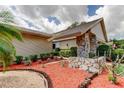 Beautiful landscaping around a one-story home featuring a stone accent facade at 3310 Tanglewood Trl, Palm Harbor, FL 34685