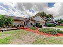Beautifully landscaped front yard with vibrant foliage and mulch surrounding a well-maintained home at 3310 Tanglewood Trl, Palm Harbor, FL 34685