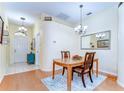 Traditional dining room featuring wood floors, chandelier and decorative mirror at 4503 Lace Cascade Ct, Lutz, FL 33558