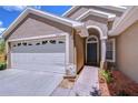 Inviting front exterior showcasing a two-car garage and landscaped walkway to the front door at 4503 Lace Cascade Ct, Lutz, FL 33558