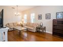 Bright living room with hardwood floors, neutral furniture, and ample natural light that is cozy at 4810 Diamonds Palm Loop, Wesley Chapel, FL 33543