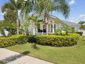 Inviting home exterior featuring a well-kept lawn, complemented by vibrant landscaping, and a cozy front porch at 525 Manns Harbor Dr, Apollo Beach, FL 33572