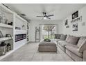 Bright and open living room with white walls, large gray sectional, and built-in shelving with electric fireplace at 5602 Wandering Willow Dr, Wesley Chapel, FL 33545