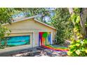 This garage features artwork on the garage doors and a painted driveway, adding unique and artistic appeal at 6014 Luana S Ln, Gulfport, FL 33707