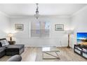Bright living room features neutral walls, wood floors, with a comfy couch and modern lighting at 6823 S Kissimmee St, Tampa, FL 33616