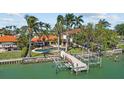 Rear view of home with a pool, dock, boat lift, and access to water for waterfront enjoyment at 8014 12Th S Ave, St Petersburg, FL 33707