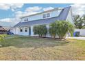 The two-story home features a unique roof, well-manicured lawn and beautiful landscaping at 8439 Boxwood Dr, Tampa, FL 33615