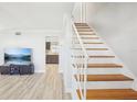 Bright living room features newly finished wood stairs, light wood-like floors, and fresh paint at 8439 Boxwood Dr, Tampa, FL 33615
