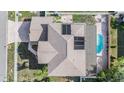 Aerial view of a home with a pool, solar panels, and lush landscaping enhancing the property's appeal at 10003 Vista Pointe Dr, Tampa, FL 33635