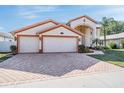 Charming home boasts an attached two-car garage and a brick-paved driveway leading to a grand entrance at 10003 Vista Pointe Dr, Tampa, FL 33635