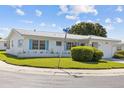 Corner lot home with a well-kept lawn, white exterior, blue shutters, and a tile roof at 10155 36Th N Way, Pinellas Park, FL 33782