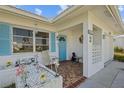 Inviting covered porch with tiled flooring, white lattice accents, and a blue front door at 10155 36Th N Way, Pinellas Park, FL 33782