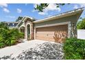 Home exterior with a two-car garage and stone accents on the entryway at 11862 Frost Aster Dr, Riverview, FL 33579