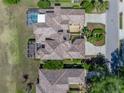 Aerial view of a meticulously maintained home with an enclosed pool and lush landscaping at 13143 Palmilla Cir, Dade City, FL 33525